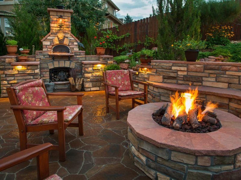 Beautiful backyard at twilight that includes a pizza oven and fire pit.